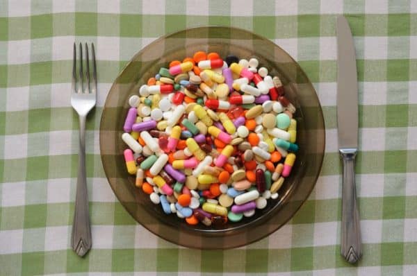 A plate with pills and a fork on it