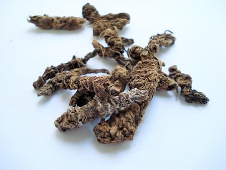 A pile of dried herbs on a white surface