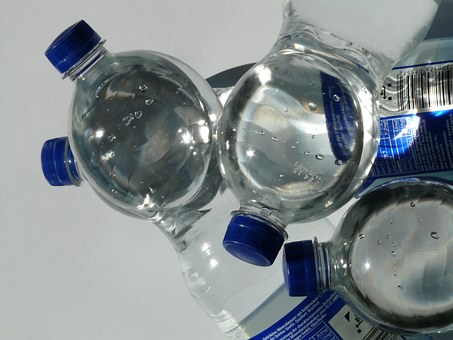 Three bottles of water with blue caps on them