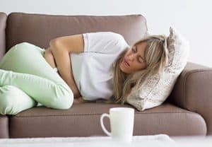 woman-stomach-pain-on-couch