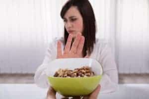 Woman Refusing Bowl Of Nut Food Offered By A Person