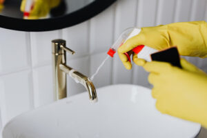 -Person-Cleaning-Washroom-Sink-With-Cleaner